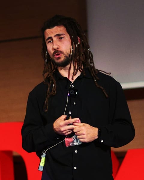 Mehmet Çetin'in TEDx sahnesinde konuşma yaptığı bir fotoğraf